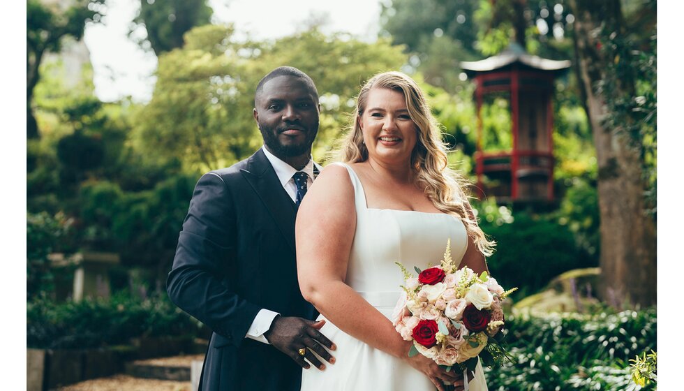 Bride and groom pose in a Sussex garden