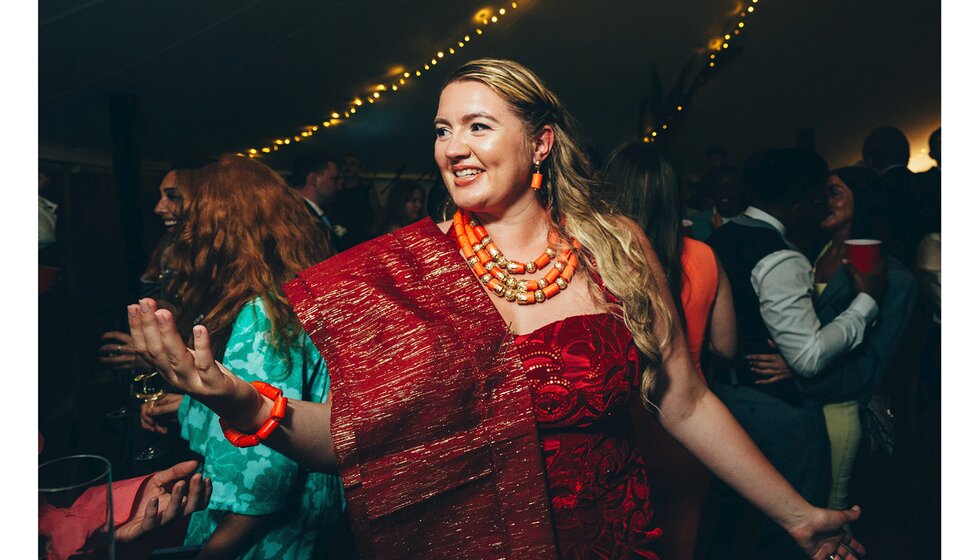 A bride wears traditional Nigerian red wedding dress during their fusion wedding