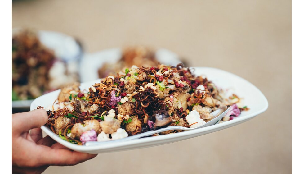 A person holds plate with British Nigerian fusion wedding food