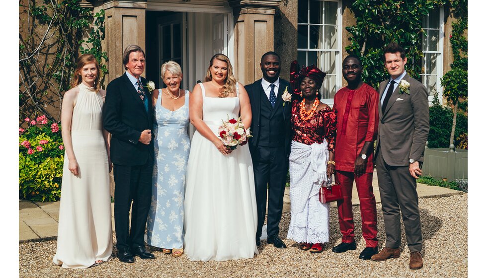 The bride and groom pose with their families during their British and Nigerian fusion wedding in Sussex