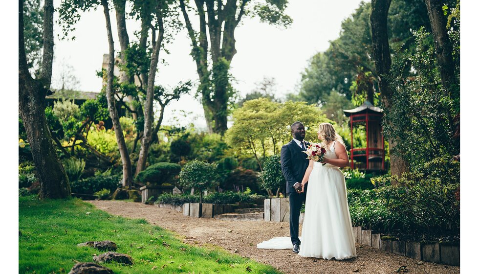 The bride and groom pose in a beautiful oriental garden in Sussex