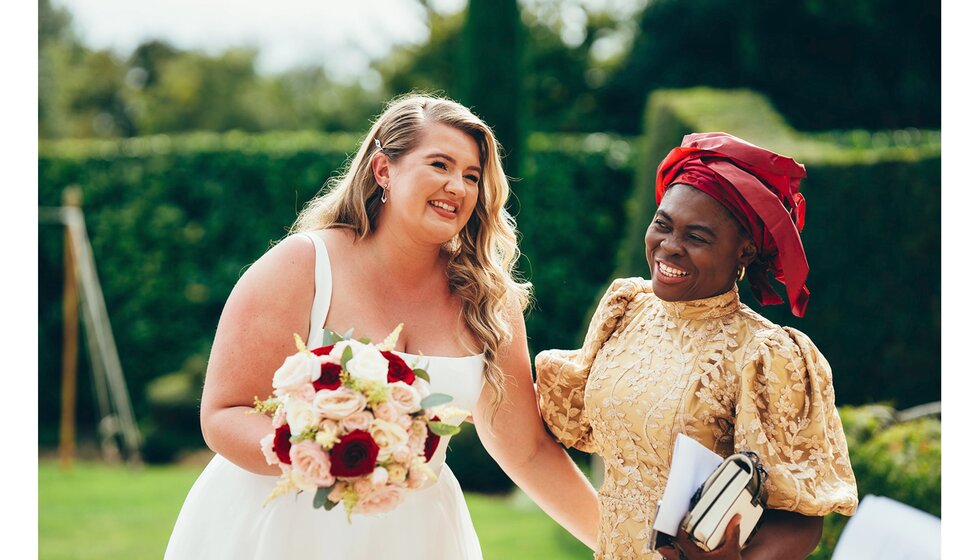 Bride with natural make-up and Hollywood wave wedding hairstyle pose with her family in law.