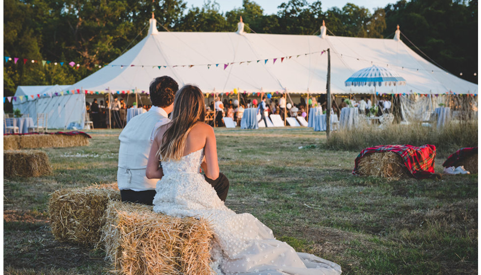 Daisy and Charlie look on the marquee and all their guests enjoying the party