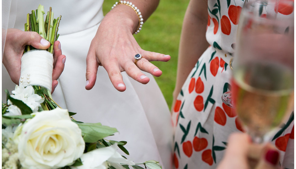 Min showing a guest her wedding ring, wearing a bracelet from her grandmother.