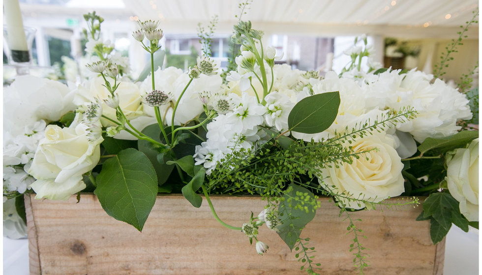 The flowers at the wedding in wooden troughs. 