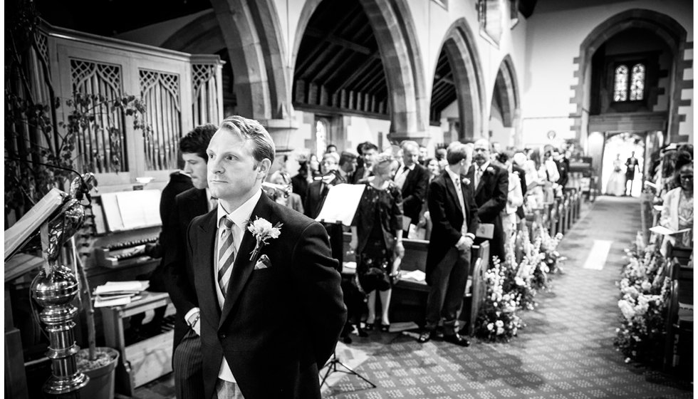 The groom waiting for Min to join him at the alter.