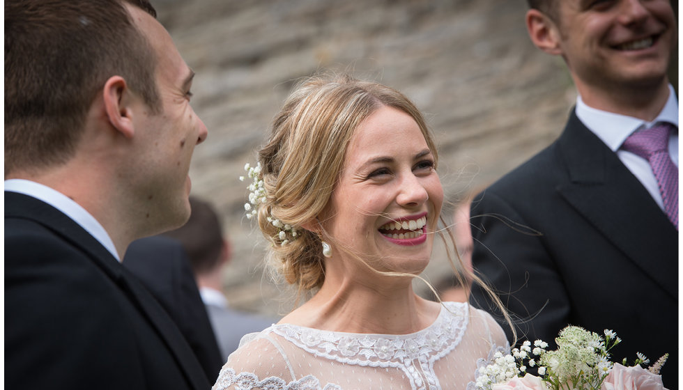 The bride looking beautiful in her wedding dress looking candid.