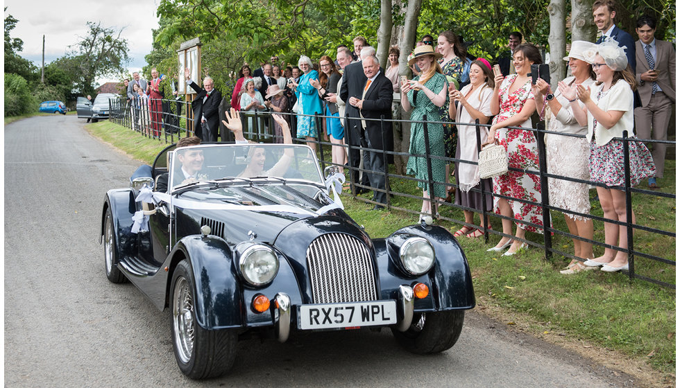 Lizzie and Ian drive from the church to the farm in a vintage navy morgan.