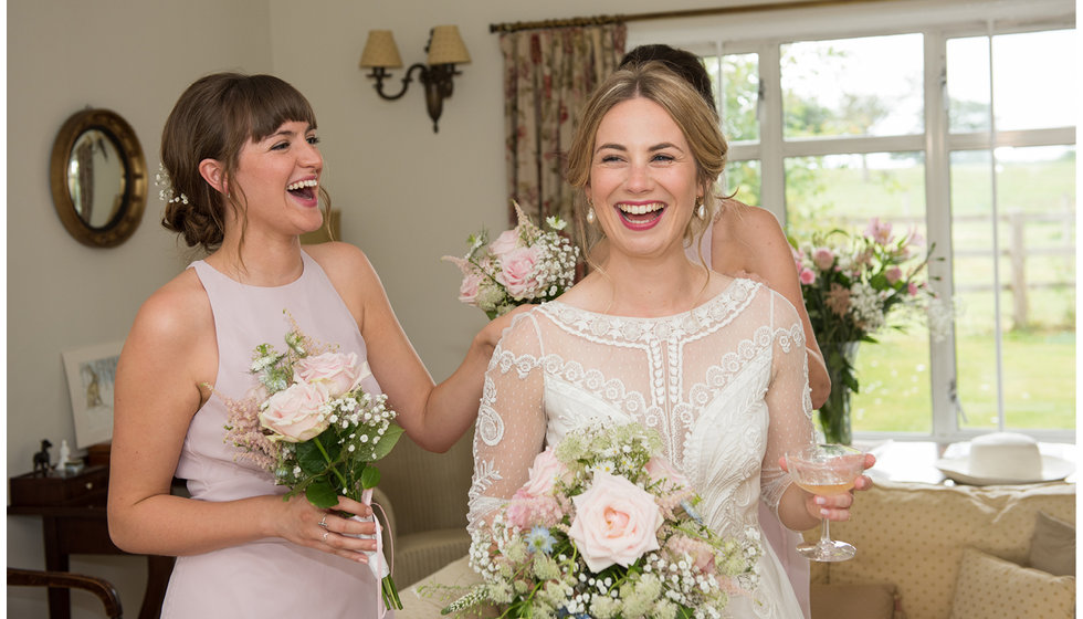 The bride in her temperley dress with her bridesmaids in the background.