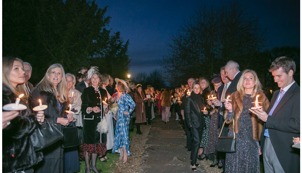 The guests outside with a candle waiting for the bride and groom.