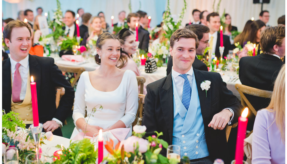 The bride and groom sitting at their wedding table.