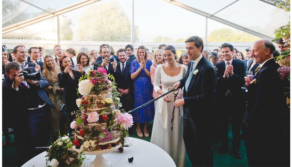 The bride and groom cut the cake. 