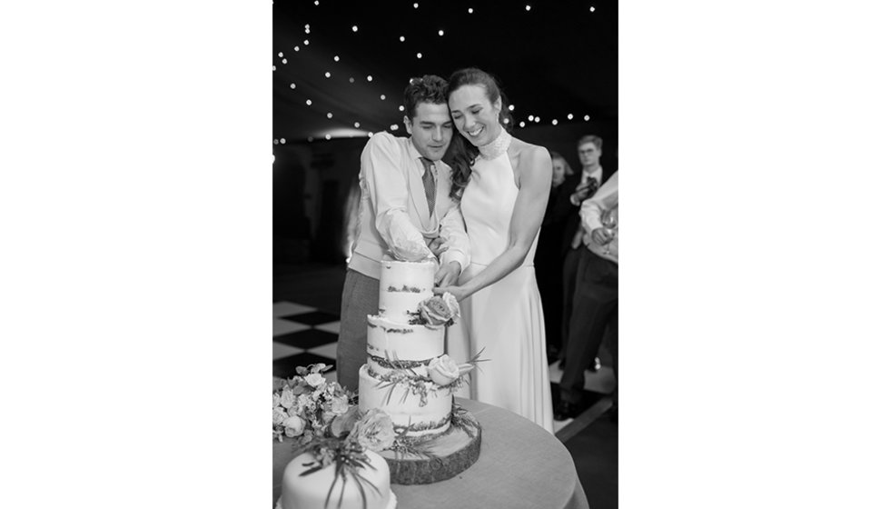 Tania and Denners cutting the wedding cake