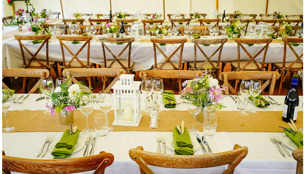 The table with lovely personal details. The colour palette is green, white and natural teak and raffia.