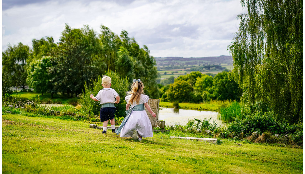 Two little children running freely in the countryside.