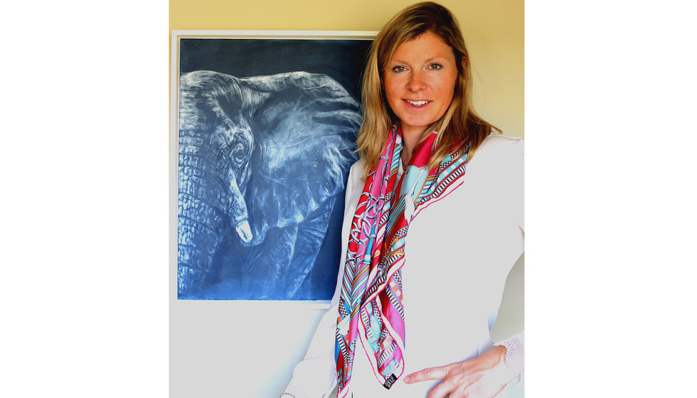 Sophie standing next to one of her paintings.