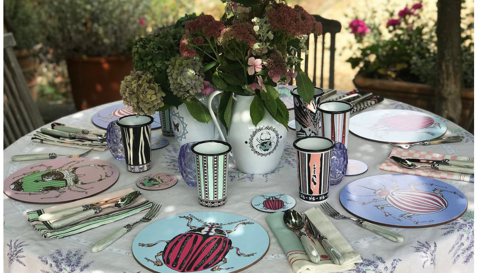 A colourful table laid outside with Bell's multicoloured beetle placemat.