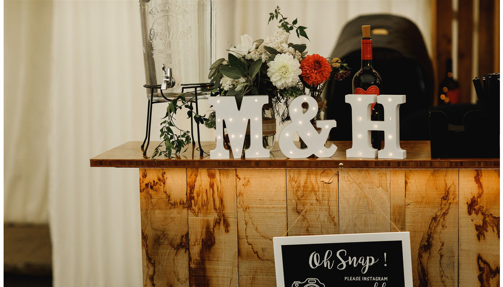 The light up lettres M and H resting on the bar.