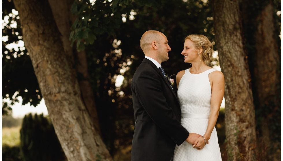 Hannah and Myles look natural posing by a tree in Hannah's parents garden.