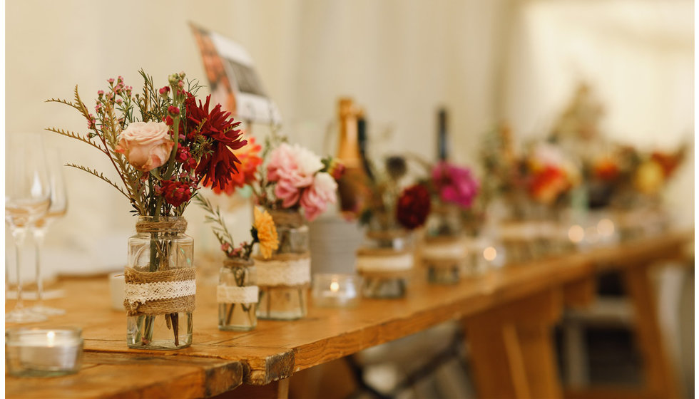 Beautiful jars of colourful flowers on the table.