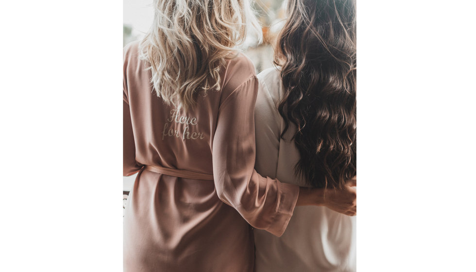 Two girls wearing embroidered dressing gowns.