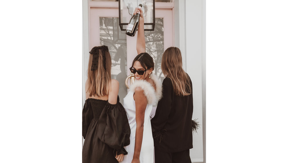 The bride-to-be and her bridesmaids outside a house.