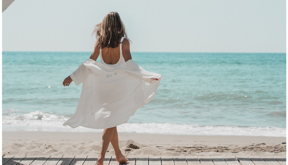 A model on a beach wearing a cover up.