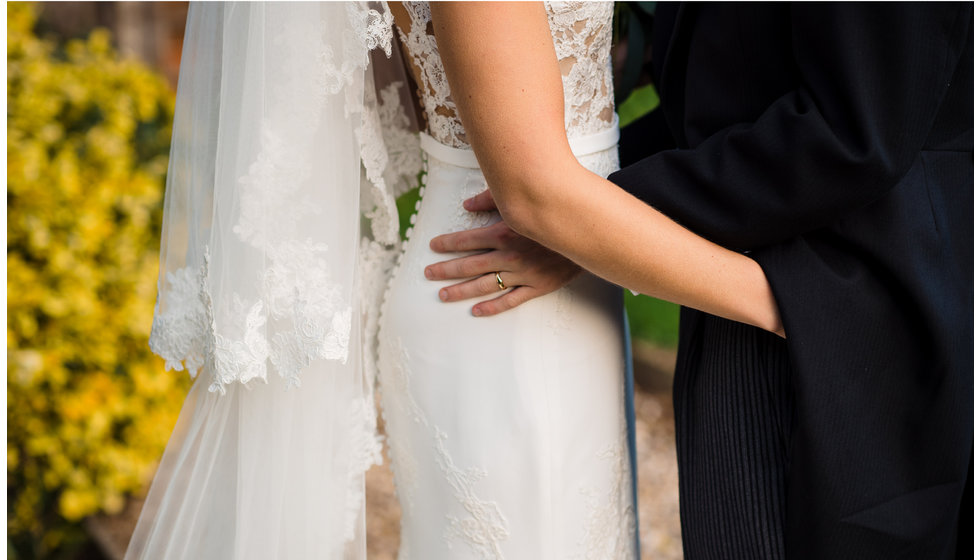 The bride and groom, a close up of her dress.