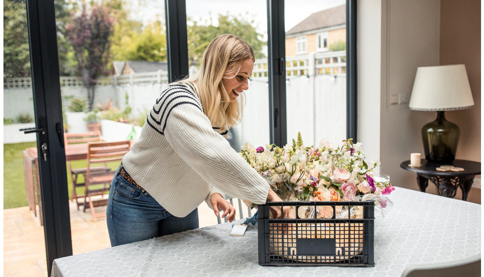 Georgie getting the flowers out of the crate and onto the table.