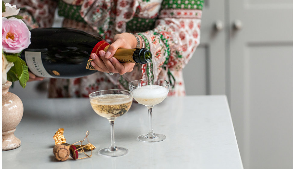 Georgie pouring Champagne into saucers.