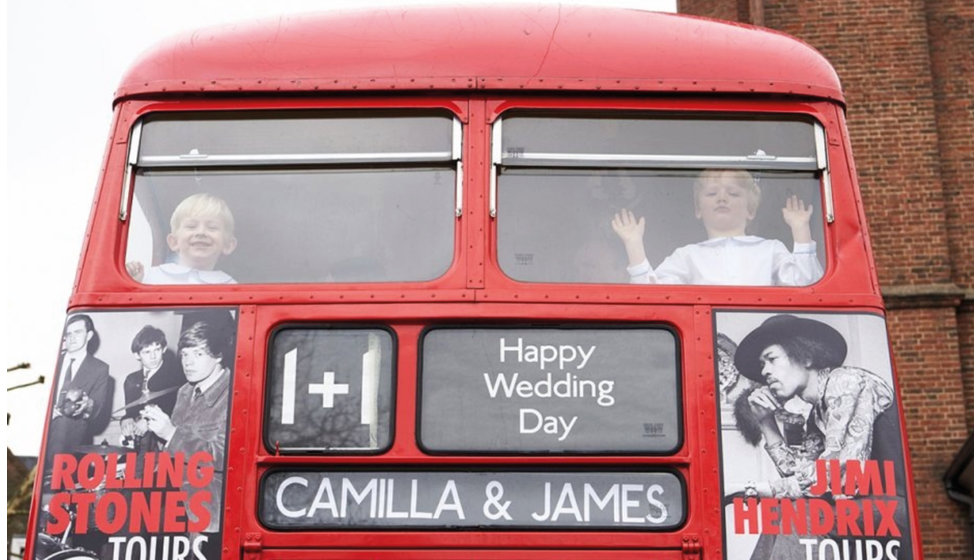 Two of the page boys at the top of the vintage red bus.