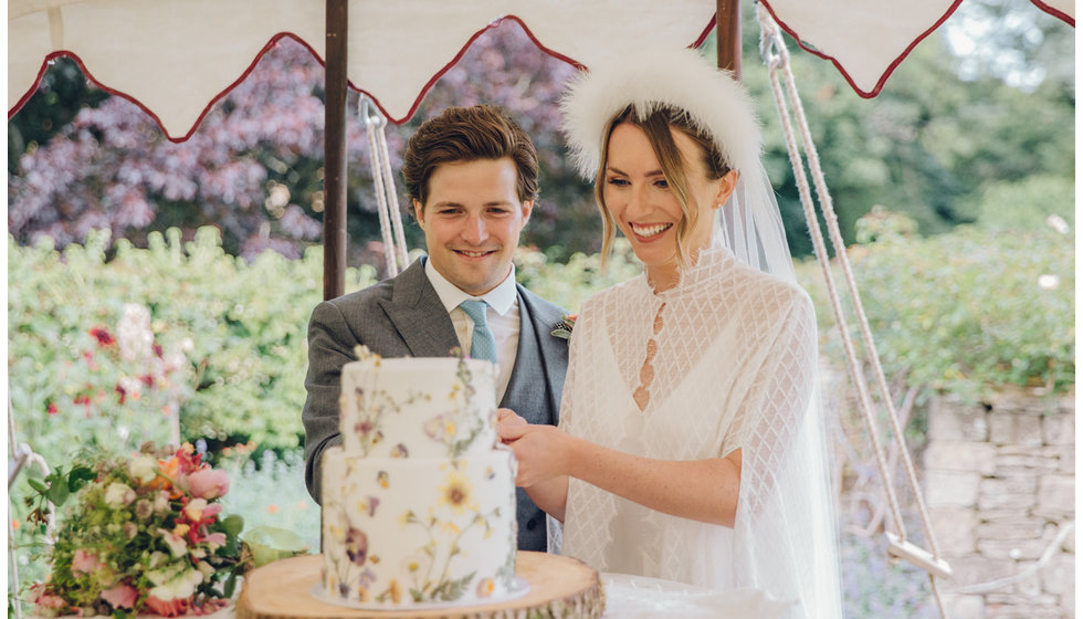 The bride and groom cut their wedding cake.