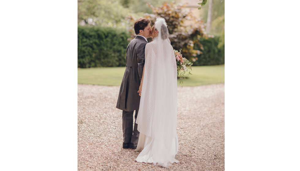 The bride and groom share a kiss whilst having their couple photos taken.