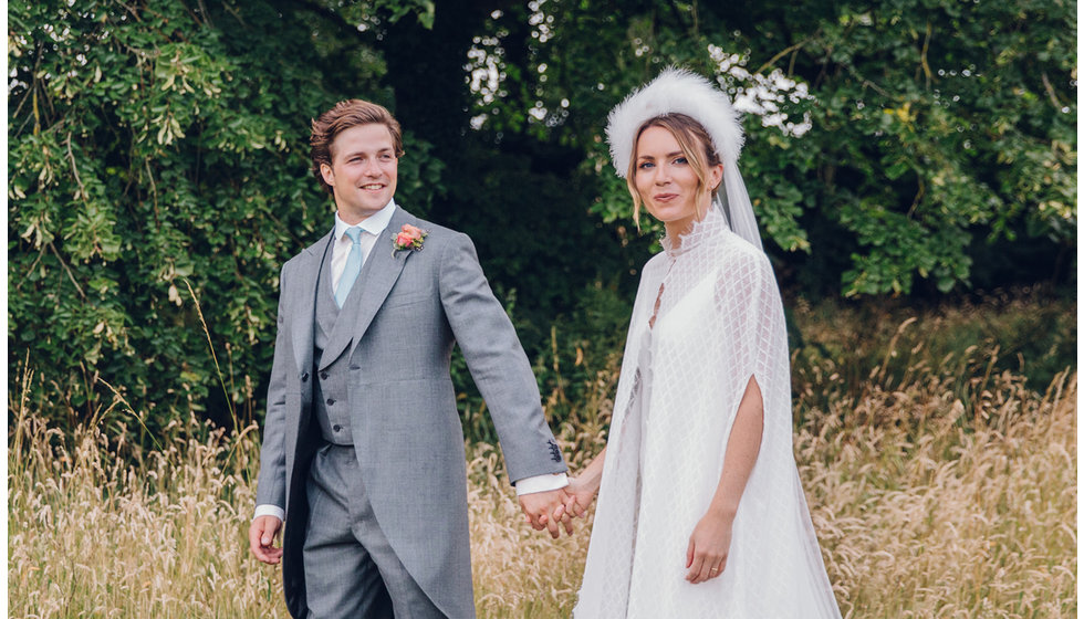 The bride and groom in a field.