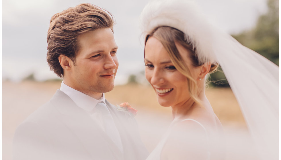 The bride and groom - a close up portrait in a field.