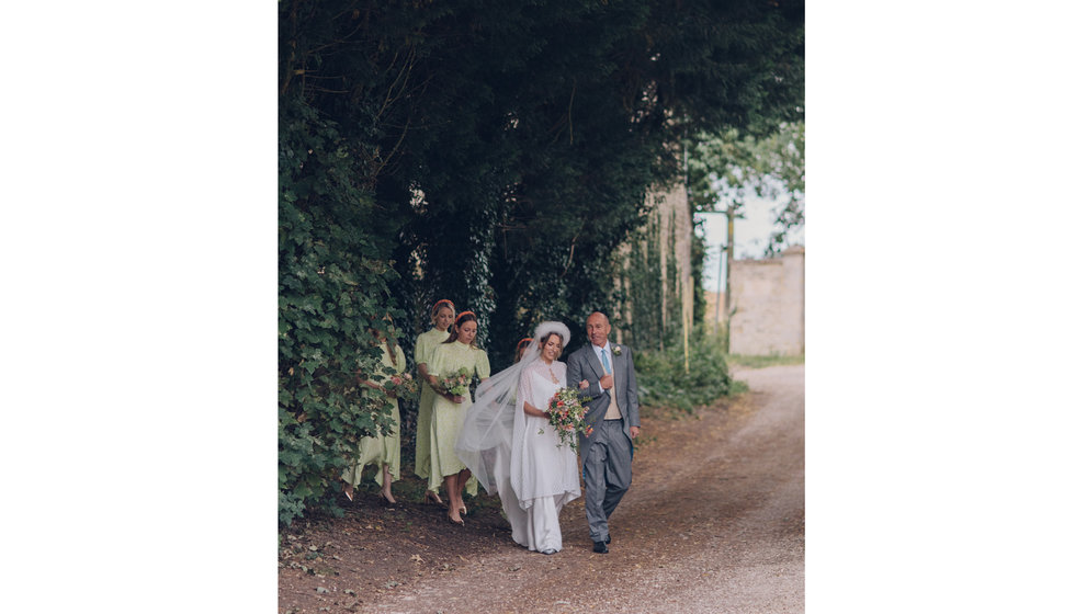 The bride, her father and her bridesmaids walking to the Church.