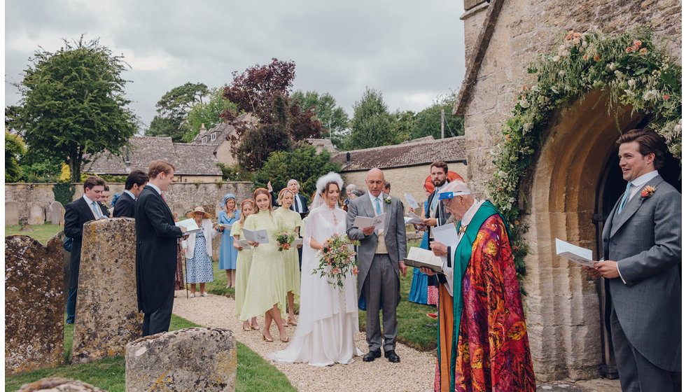 The wedding party sung the first him outside all spaced out, the vicar wears a covid secure visor.