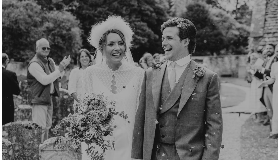 A black and white photo of the bride and groom walking out of the Church.