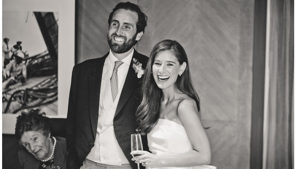 The bride and groom smile and drink champagne during the speaches.