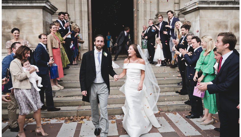 The bride and groom walking down the steps of the Brompton Oratory.