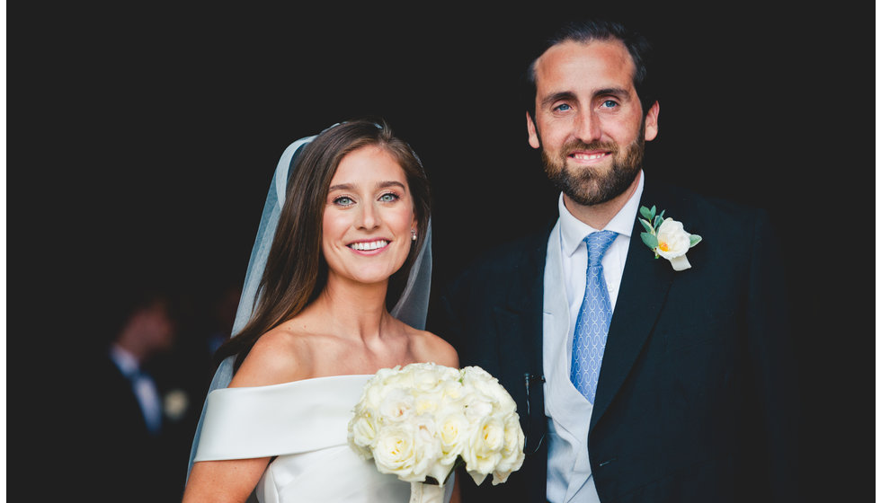 The bride and groom standing outside the church. The bride looked radiant having had her make up done by a Charlotte Tilbury Make up Artist.