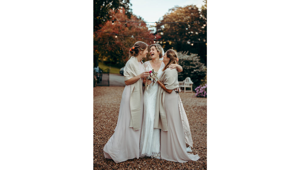 The bride and her two bridesmaids wearing pink silk dresses.