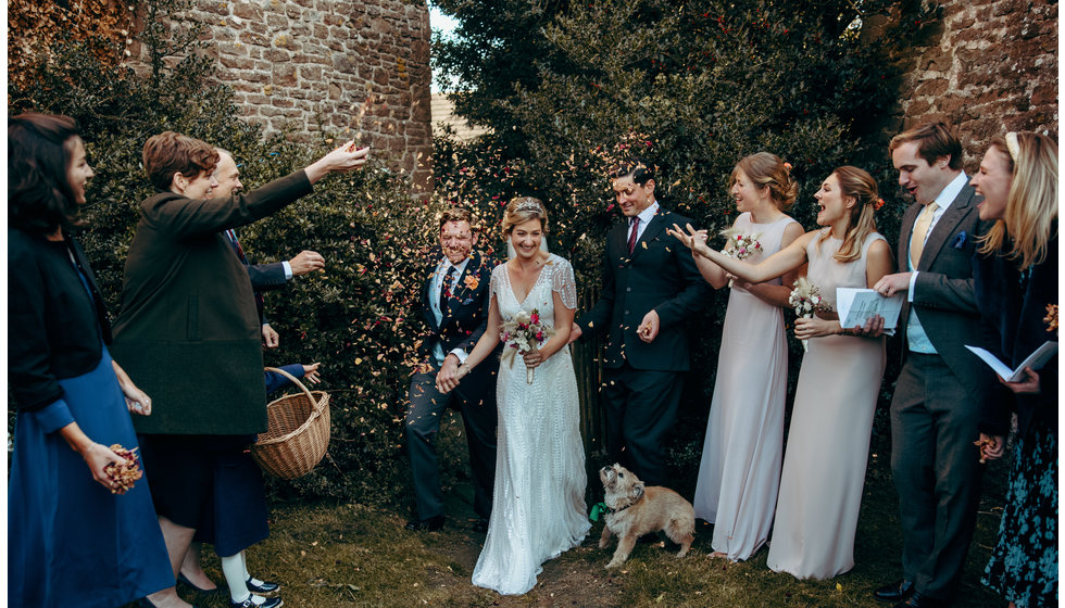 The bride and groom walking through a line of their nearest and dearest throwing confetti.