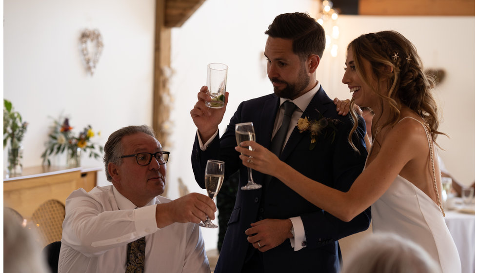 The bride and groom and guests toasting with champagne at their intimate wedding reception. 