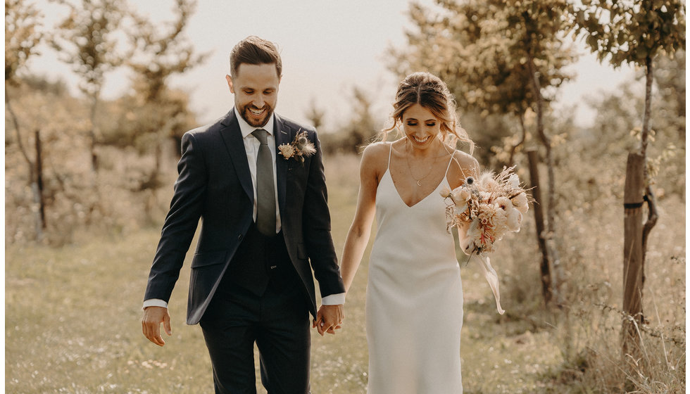 The bride and groom walking outside on their wedding day. 