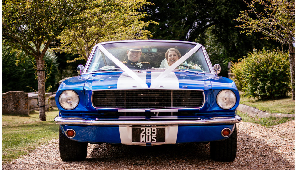 The bride and groom in their wedding car.