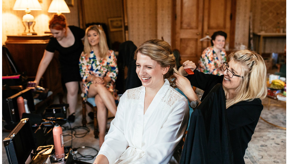 The bride having her hair done on her wedding day.