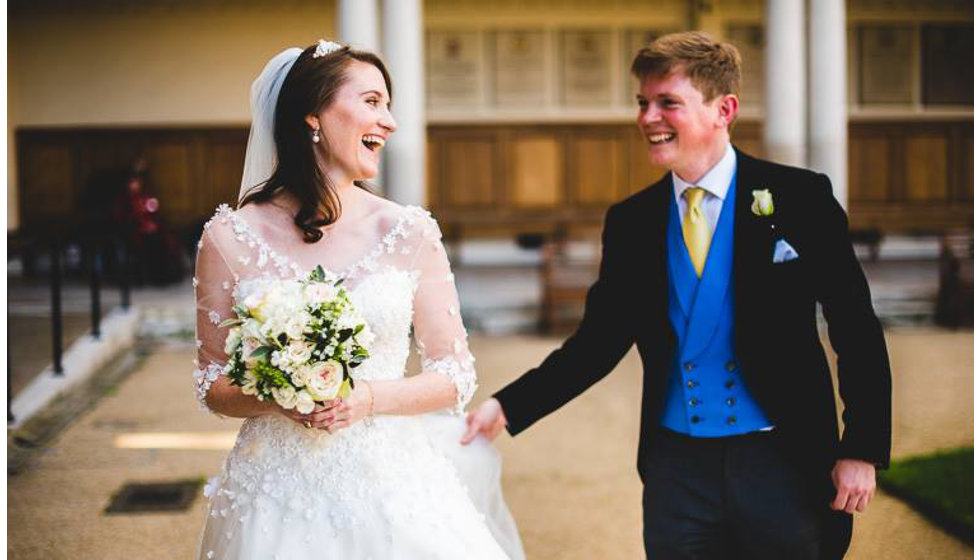 The bride and groom laughing together outside the Royal Hospital Chelsea. 