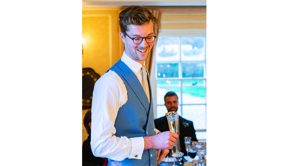 The groom wearing a sky blue waistcoat.