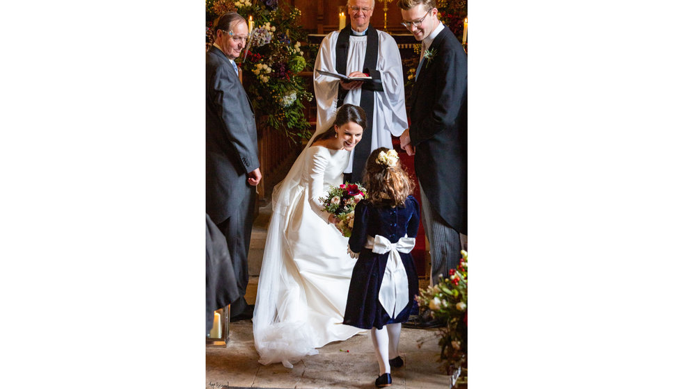 Edwina talking to one of her flower girls wearing a little navy dress with a white bow. 